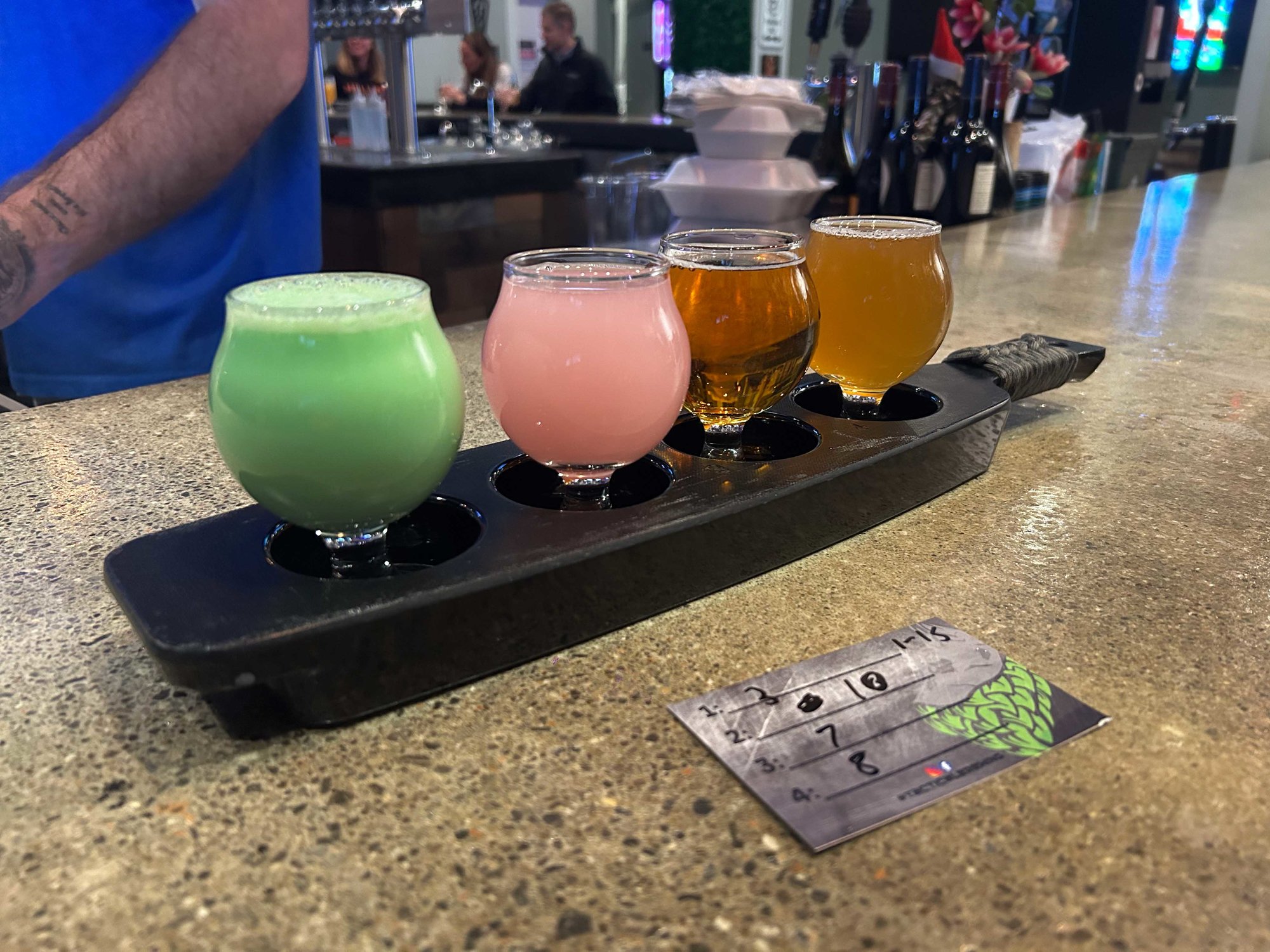 flight of four beers on a bar counter